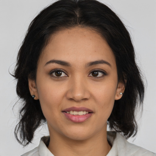 Joyful latino young-adult female with medium  brown hair and brown eyes