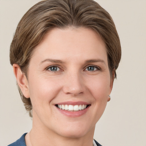 Joyful white young-adult female with short  brown hair and grey eyes