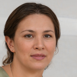 Joyful white adult female with medium  brown hair and brown eyes