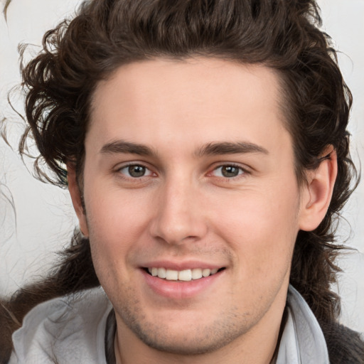 Joyful white young-adult male with medium  brown hair and brown eyes