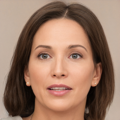 Joyful white young-adult female with medium  brown hair and grey eyes