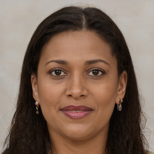Joyful black young-adult female with long  brown hair and brown eyes