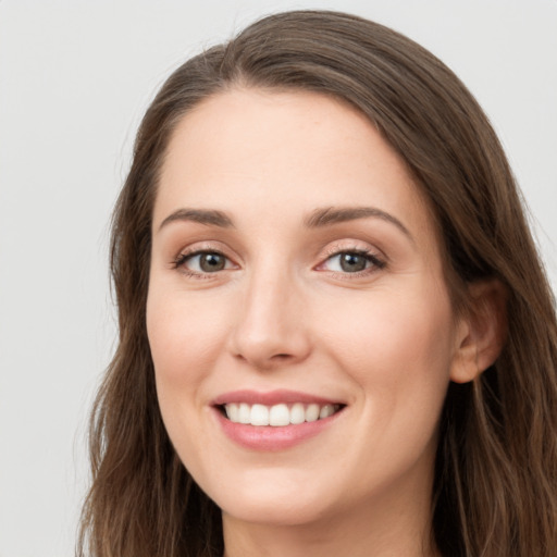 Joyful white young-adult female with long  brown hair and green eyes