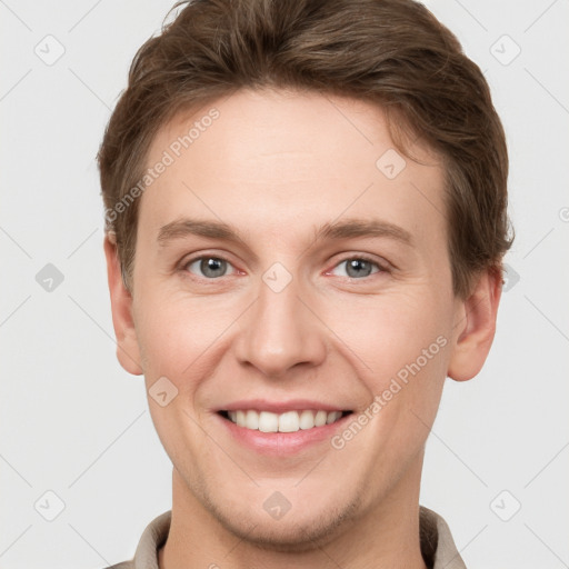 Joyful white young-adult male with short  brown hair and grey eyes