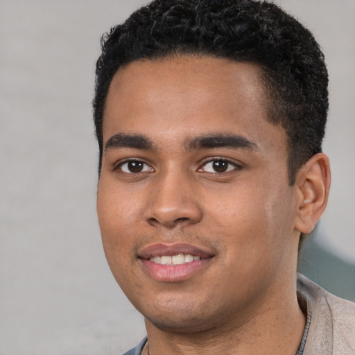 Joyful black young-adult male with short  black hair and brown eyes