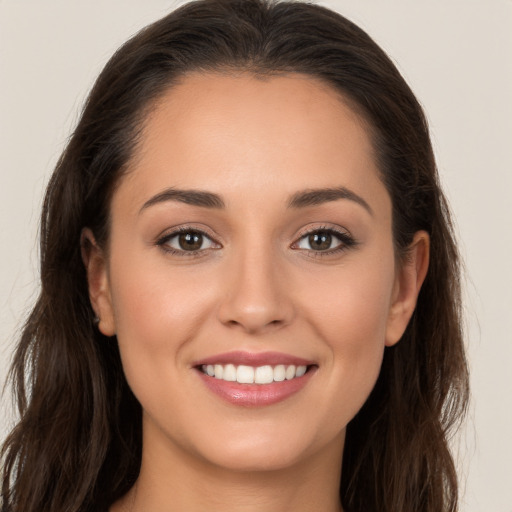 Joyful white young-adult female with long  brown hair and brown eyes