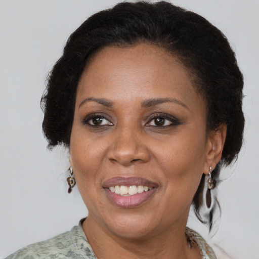 Joyful black adult female with medium  brown hair and brown eyes