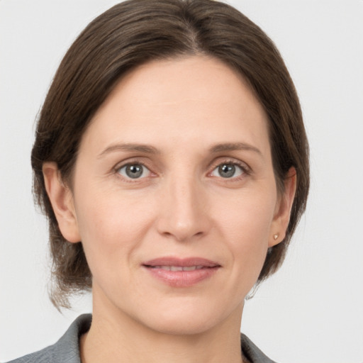 Joyful white adult female with medium  brown hair and grey eyes