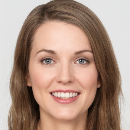 Joyful white young-adult female with long  brown hair and green eyes