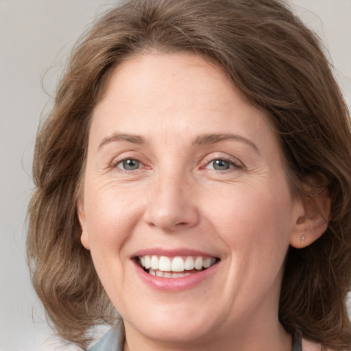 Joyful white adult female with medium  brown hair and grey eyes