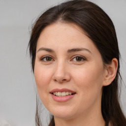 Joyful white adult female with long  brown hair and brown eyes