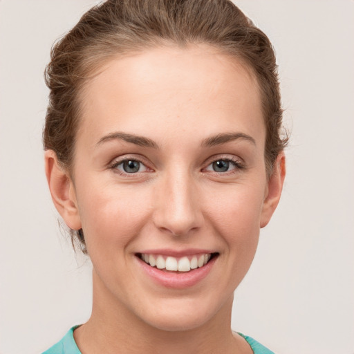 Joyful white young-adult female with short  brown hair and grey eyes