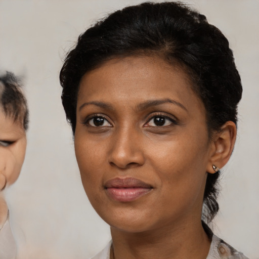 Joyful black young-adult female with medium  brown hair and brown eyes