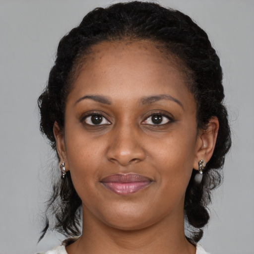 Joyful black young-adult female with medium  brown hair and brown eyes