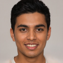 Joyful latino young-adult male with short  black hair and brown eyes