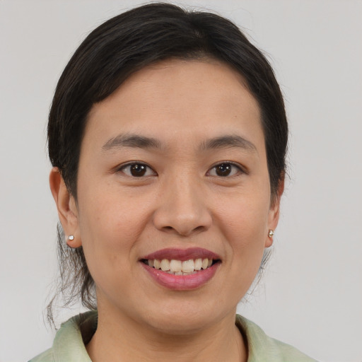 Joyful asian young-adult female with medium  brown hair and brown eyes