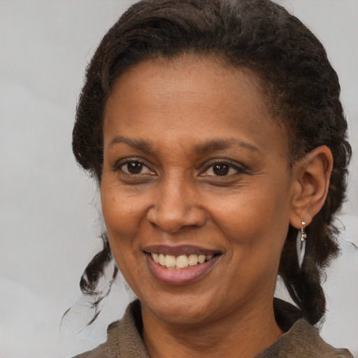 Joyful black adult female with medium  brown hair and brown eyes
