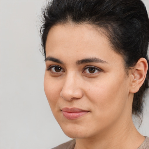 Joyful latino young-adult female with medium  brown hair and brown eyes
