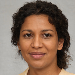 Joyful black adult female with medium  brown hair and brown eyes