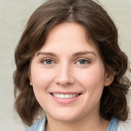 Joyful white young-adult female with medium  brown hair and green eyes