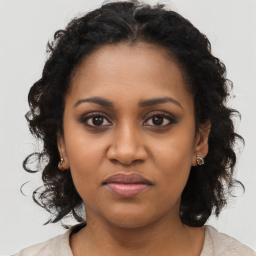 Joyful black young-adult female with long  black hair and brown eyes