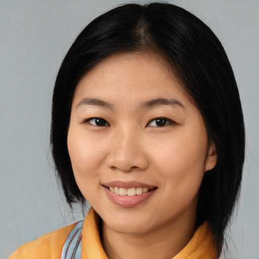 Joyful asian young-adult female with medium  black hair and brown eyes