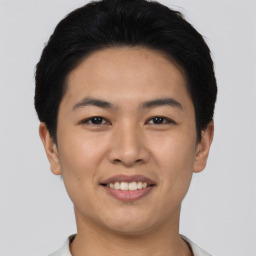 Joyful asian young-adult male with short  black hair and brown eyes