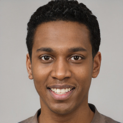 Joyful black young-adult male with short  black hair and brown eyes