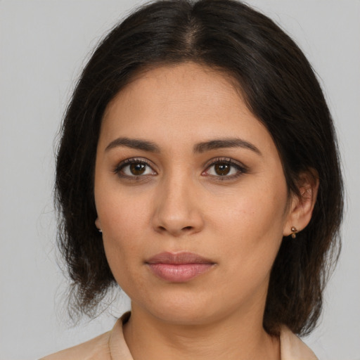 Joyful latino young-adult female with medium  brown hair and brown eyes