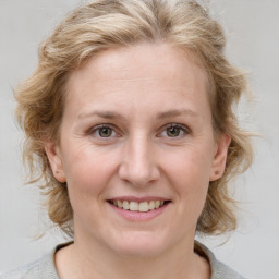 Joyful white young-adult female with medium  brown hair and blue eyes