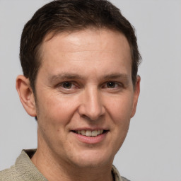 Joyful white adult male with short  brown hair and grey eyes