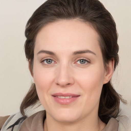 Joyful white young-adult female with medium  brown hair and grey eyes