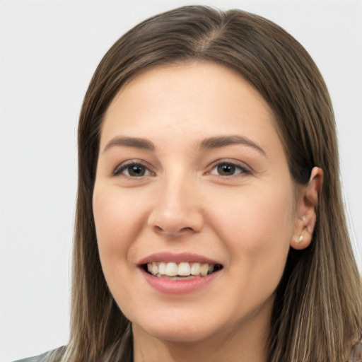 Joyful white young-adult female with long  brown hair and brown eyes