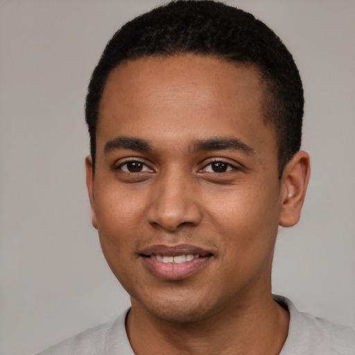 Joyful black young-adult male with short  black hair and brown eyes