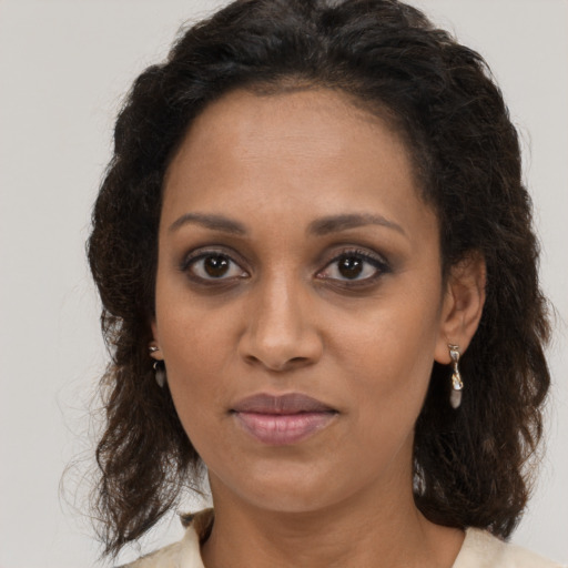 Joyful black adult female with medium  brown hair and brown eyes