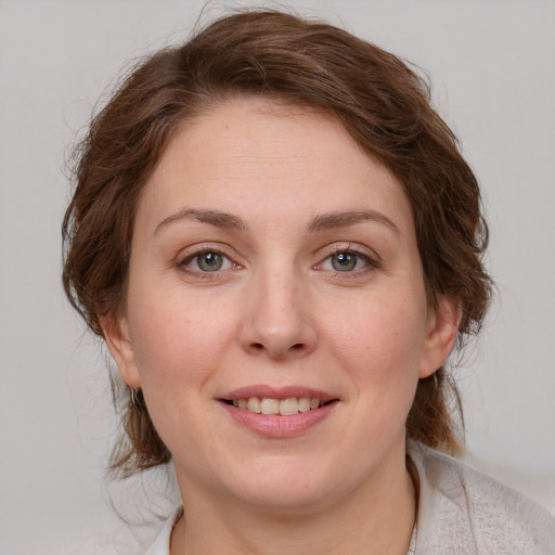 Joyful white young-adult female with medium  brown hair and green eyes