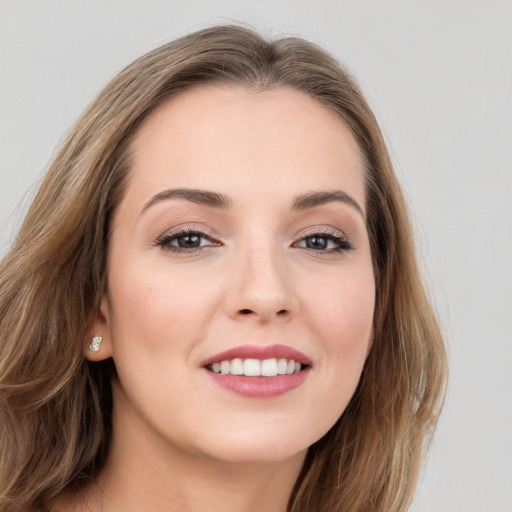 Joyful white young-adult female with long  brown hair and grey eyes