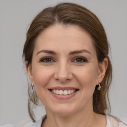 Joyful white young-adult female with medium  brown hair and grey eyes