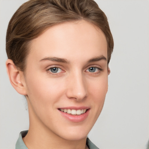 Joyful white young-adult female with short  brown hair and grey eyes