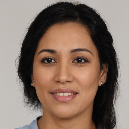 Joyful latino young-adult female with medium  brown hair and brown eyes