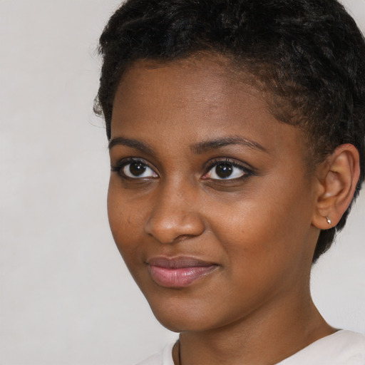 Joyful black young-adult female with short  brown hair and brown eyes
