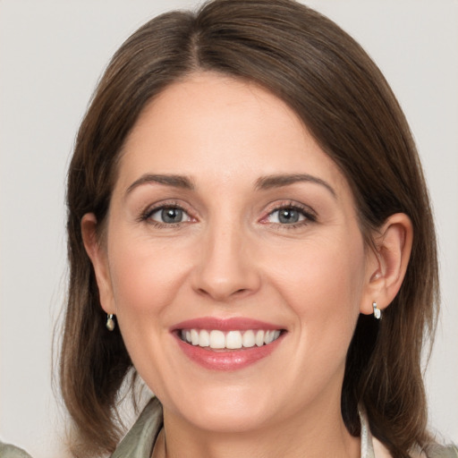 Joyful white young-adult female with medium  brown hair and grey eyes