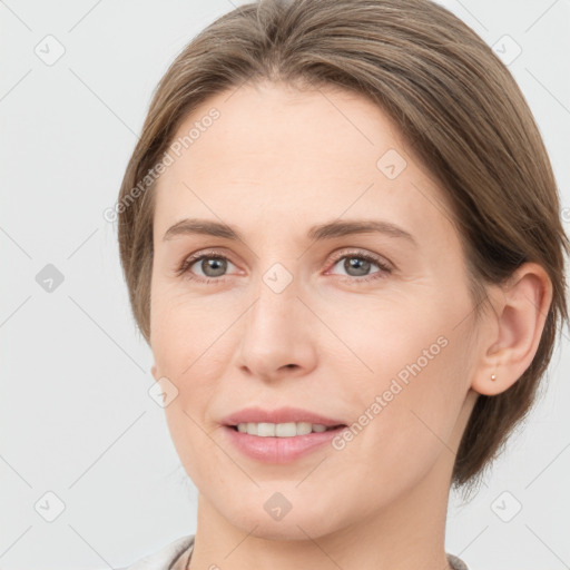 Joyful white young-adult female with medium  brown hair and grey eyes