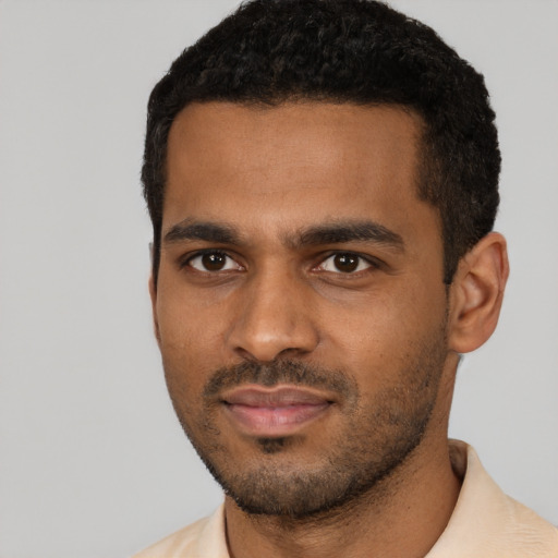 Joyful black young-adult male with short  black hair and brown eyes