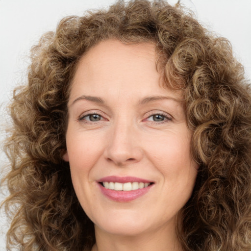 Joyful white adult female with long  brown hair and green eyes