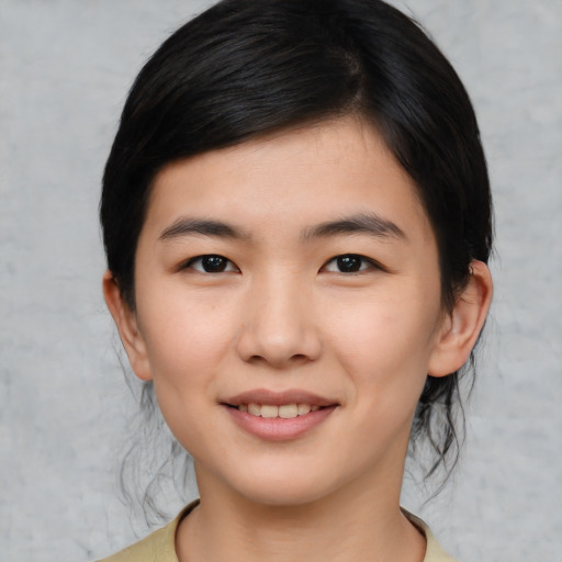 Joyful asian young-adult female with medium  black hair and brown eyes