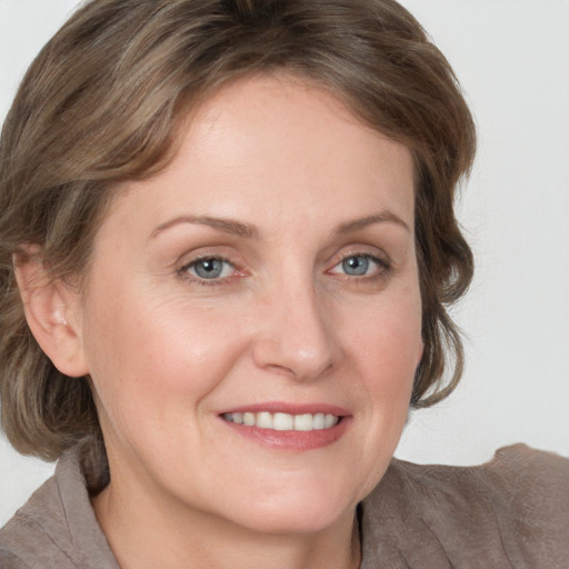 Joyful white adult female with medium  brown hair and grey eyes