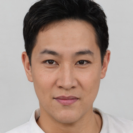 Joyful asian young-adult male with short  brown hair and brown eyes