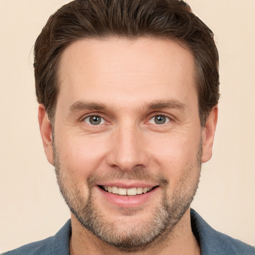 Joyful white young-adult male with short  brown hair and grey eyes