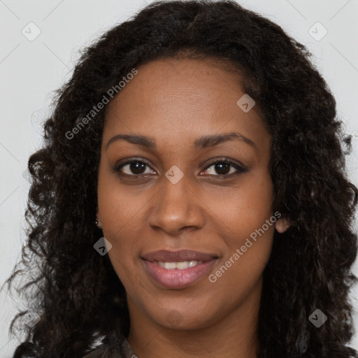 Joyful black young-adult female with long  brown hair and brown eyes